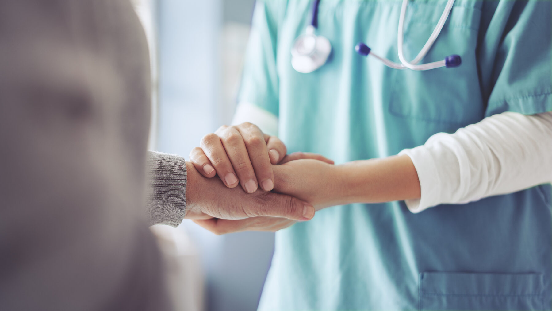 Caregiver holding a resident's hand